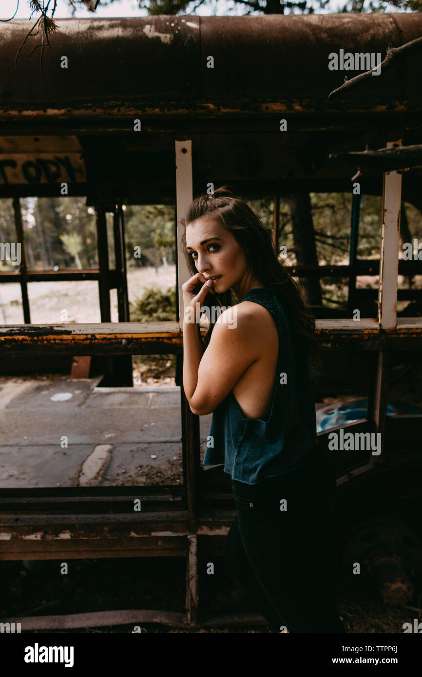 Portrait von selbstbewussten jungen Frau, die durch verlassene Fahrzeug Stockfoto