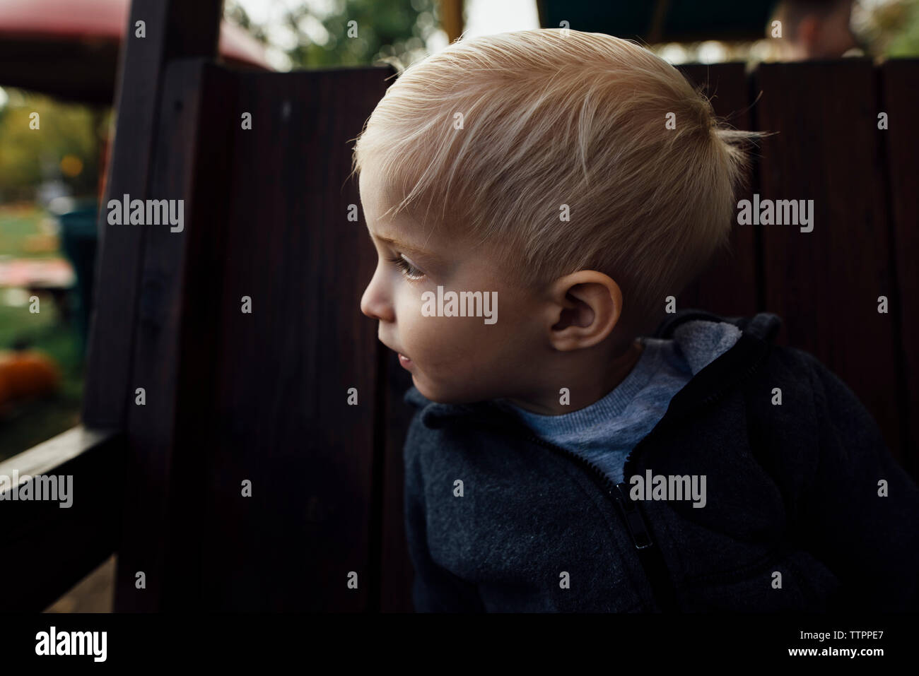 Nahaufnahme der Junge weg schauen beim Sitzen im Freien spielen Ausrüstung Stockfoto