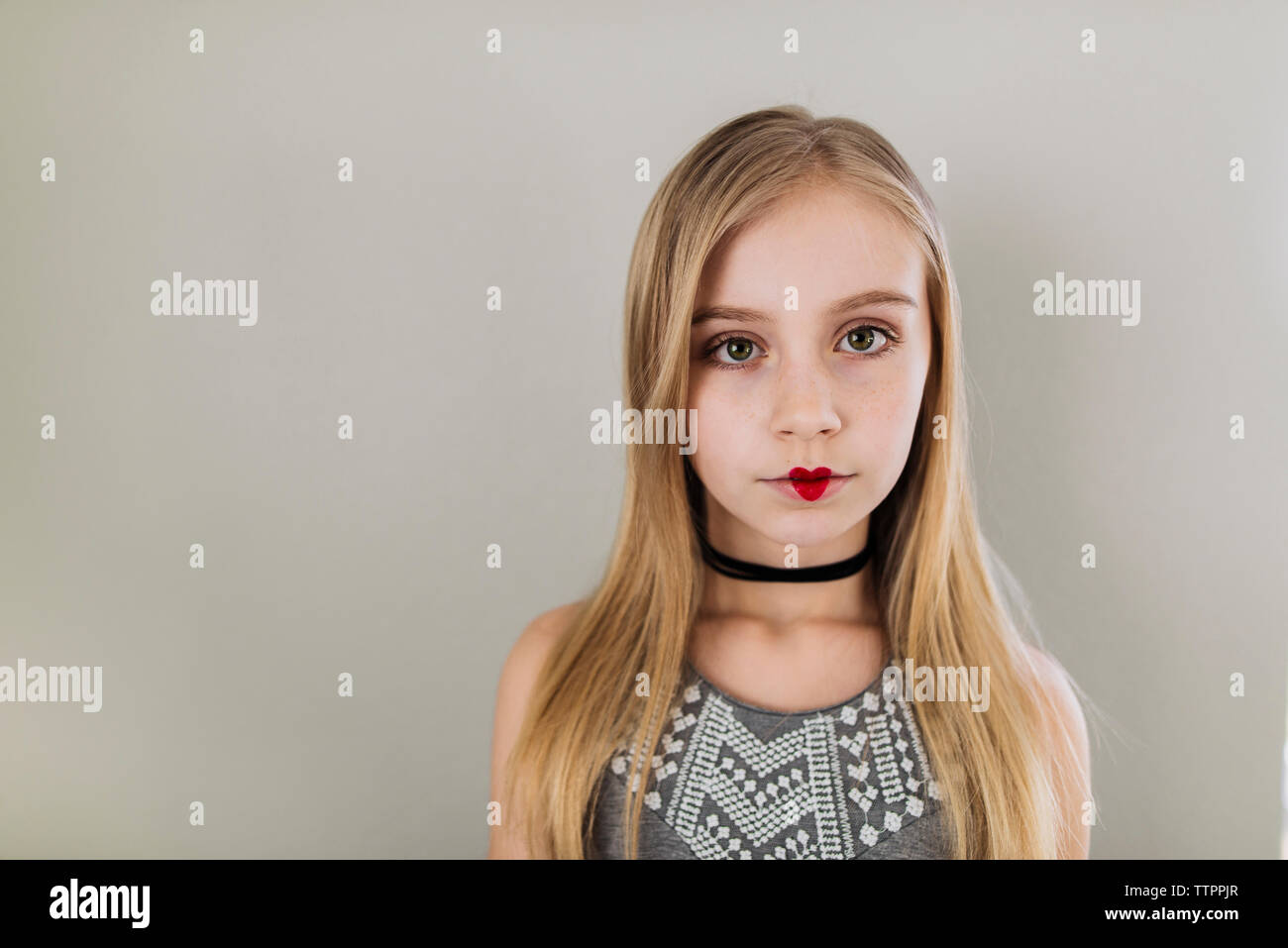 Portrait von Mädchen mit Herzform Lippenstift gegen Wand Stockfoto