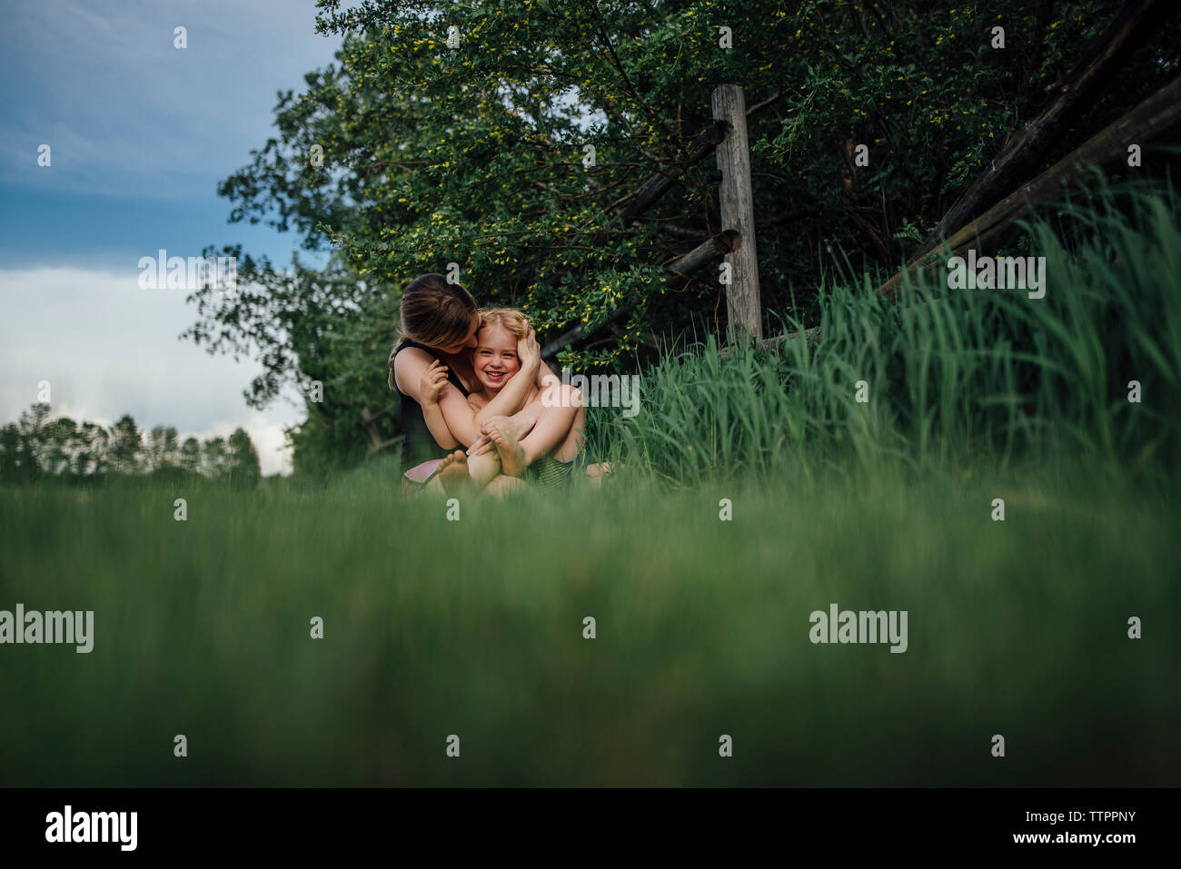 Mutter Sohn umarmen fröhlich auf der Wiese im Park Stockfoto