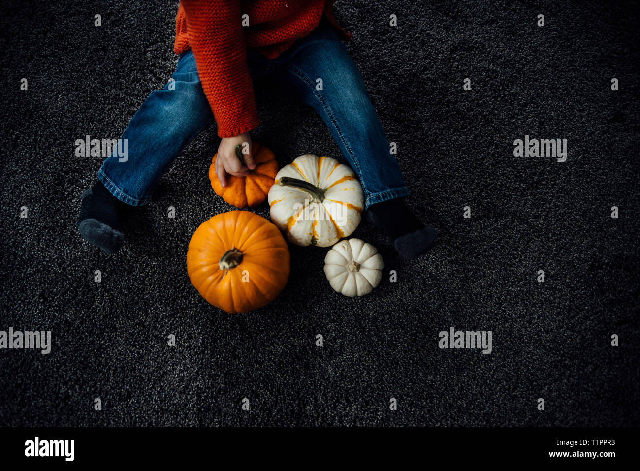 Hohe Betrachtungswinkel der Junge spielt mit Kürbissen zu Hause während Halloween Stockfoto