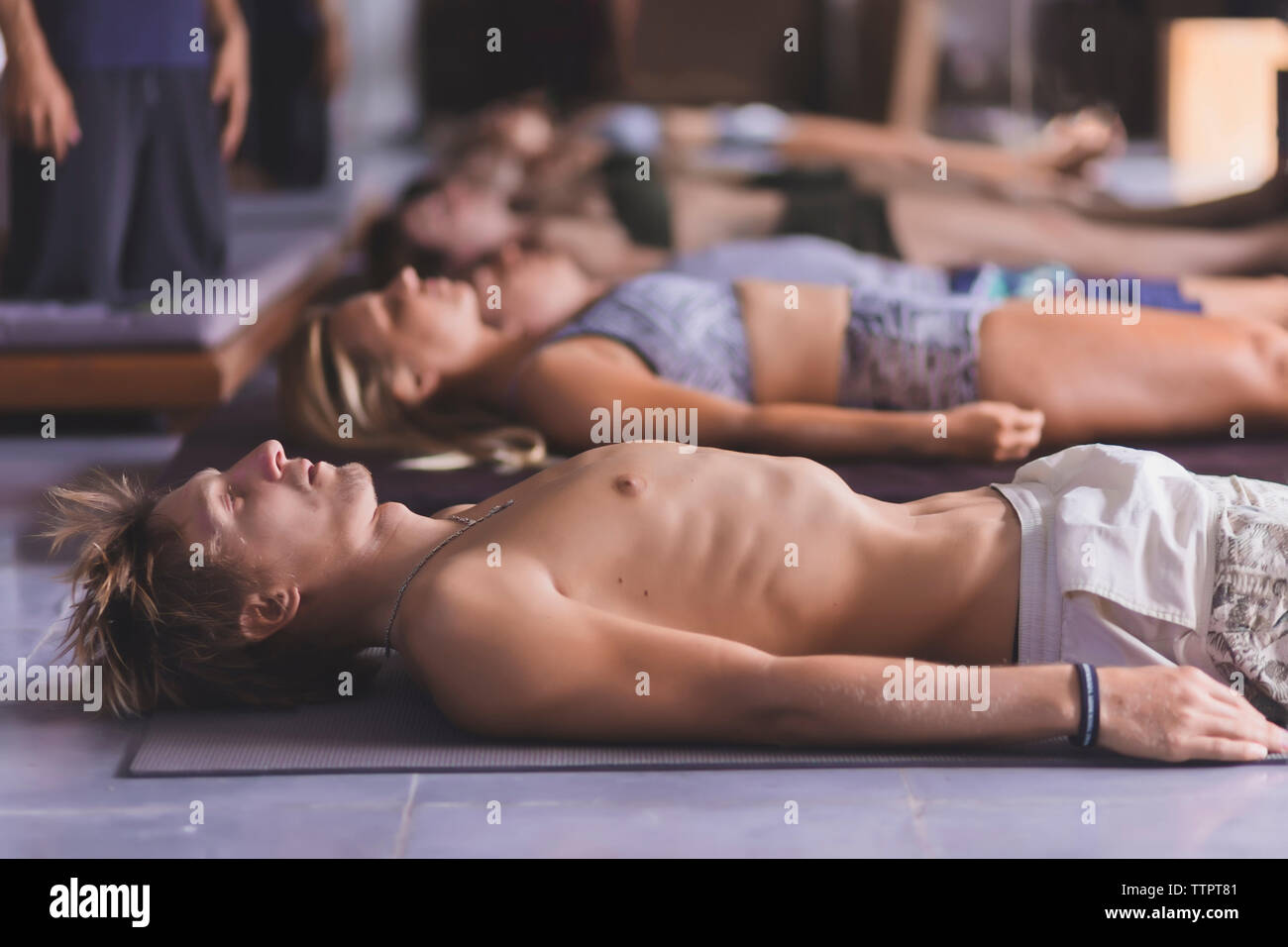 Hohe Betrachtungswinkel von Mann und Frauen, die Entspannungsübung während nebeneinander liegend auf Trainingsmatte Stockfoto