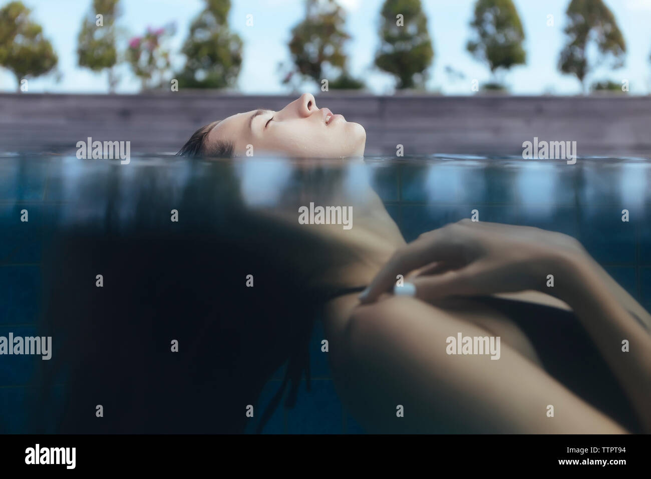 Frau mit geschlossenen Augen auf dem Wasser schwimmend Stockfoto