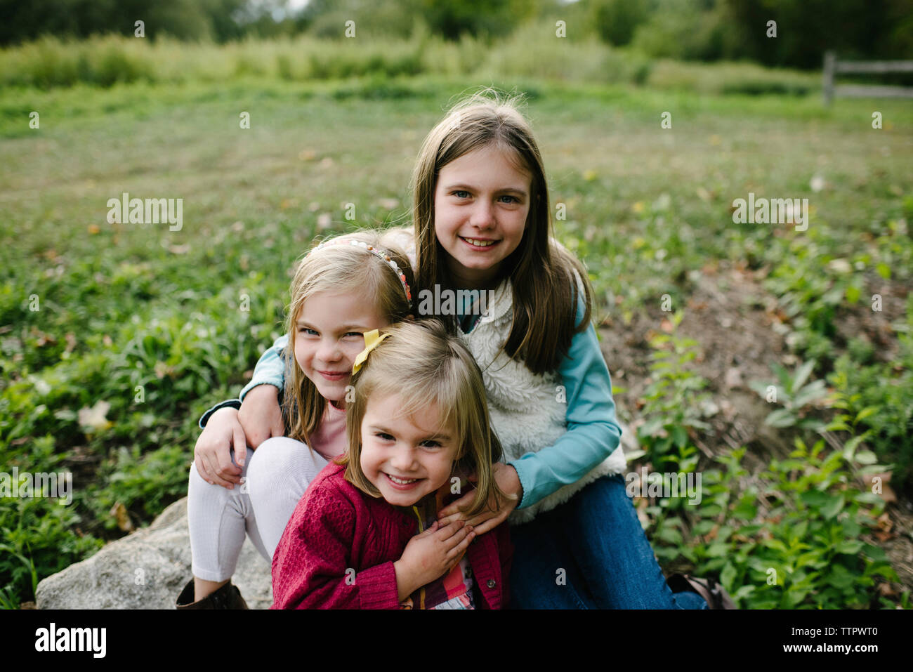 Portrait von fröhlichen Schwestern auf dem Feld im Park Stockfoto