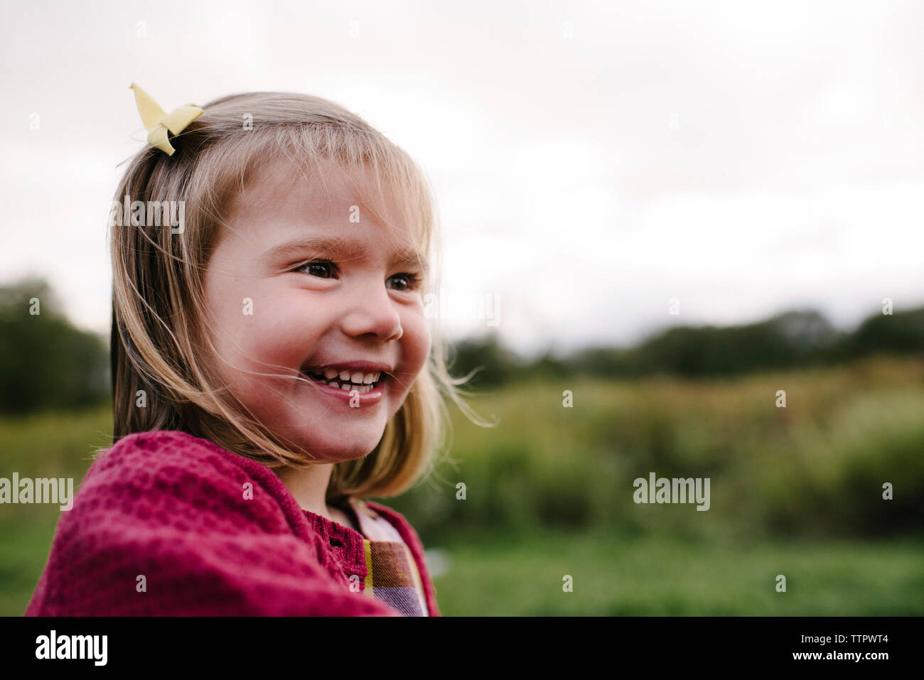 Fröhliches Mädchen weg schauen auf dem Feld im Park Stockfoto