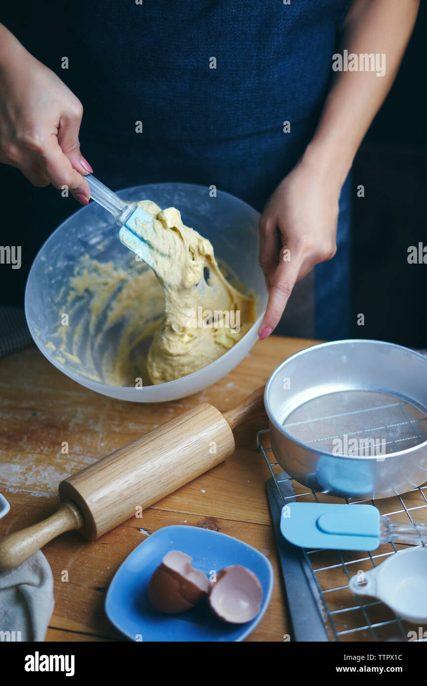 Mittelteil der Frau misch Ei und Mehl in Schüssel am Küche Stockfoto