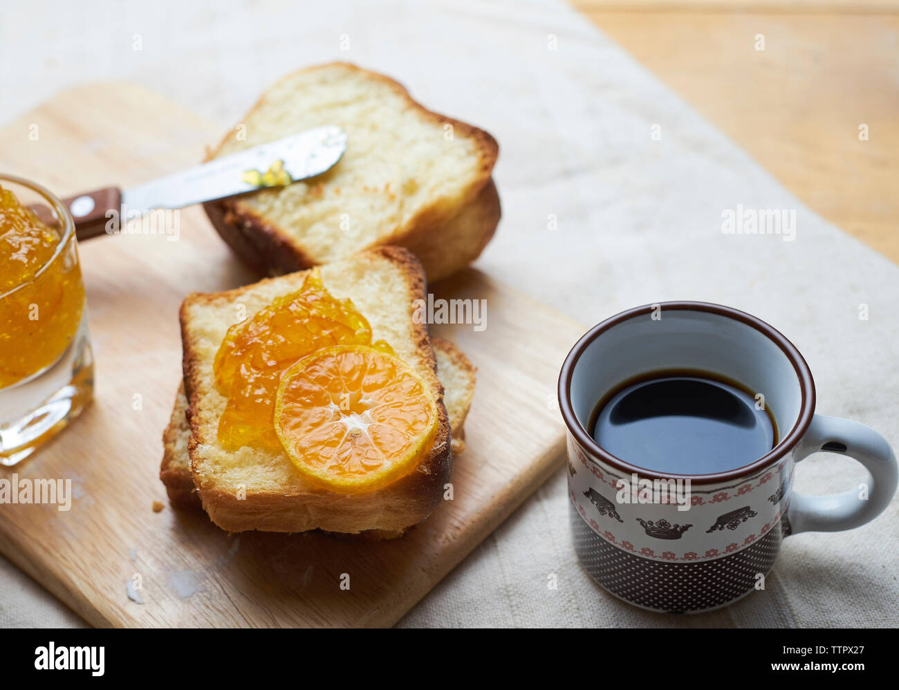 In der Nähe von Brot und Marmelade auf schneidebrett von schwarzen Kaffee Stockfoto