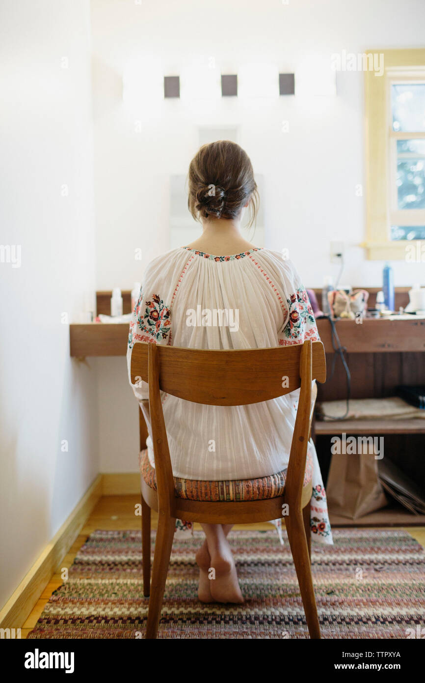 Braut sitzt im Stuhl, während Sie Ihr Haar vor Ihrer Hochzeit getan Stockfoto