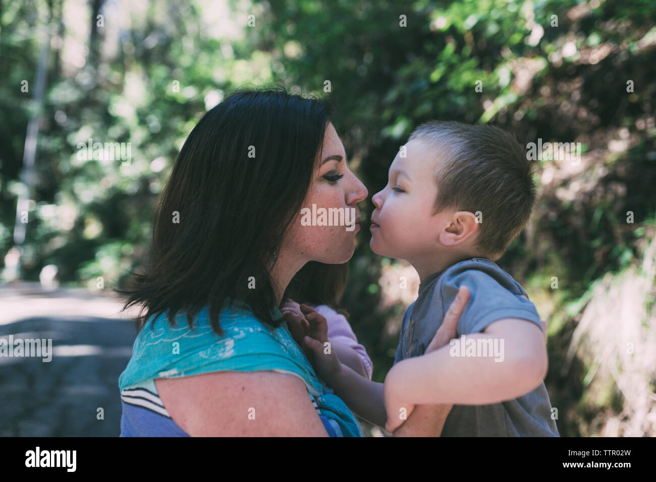 Seitenansicht von Mutter und Sohn über im Park zu küssen. Stockfoto