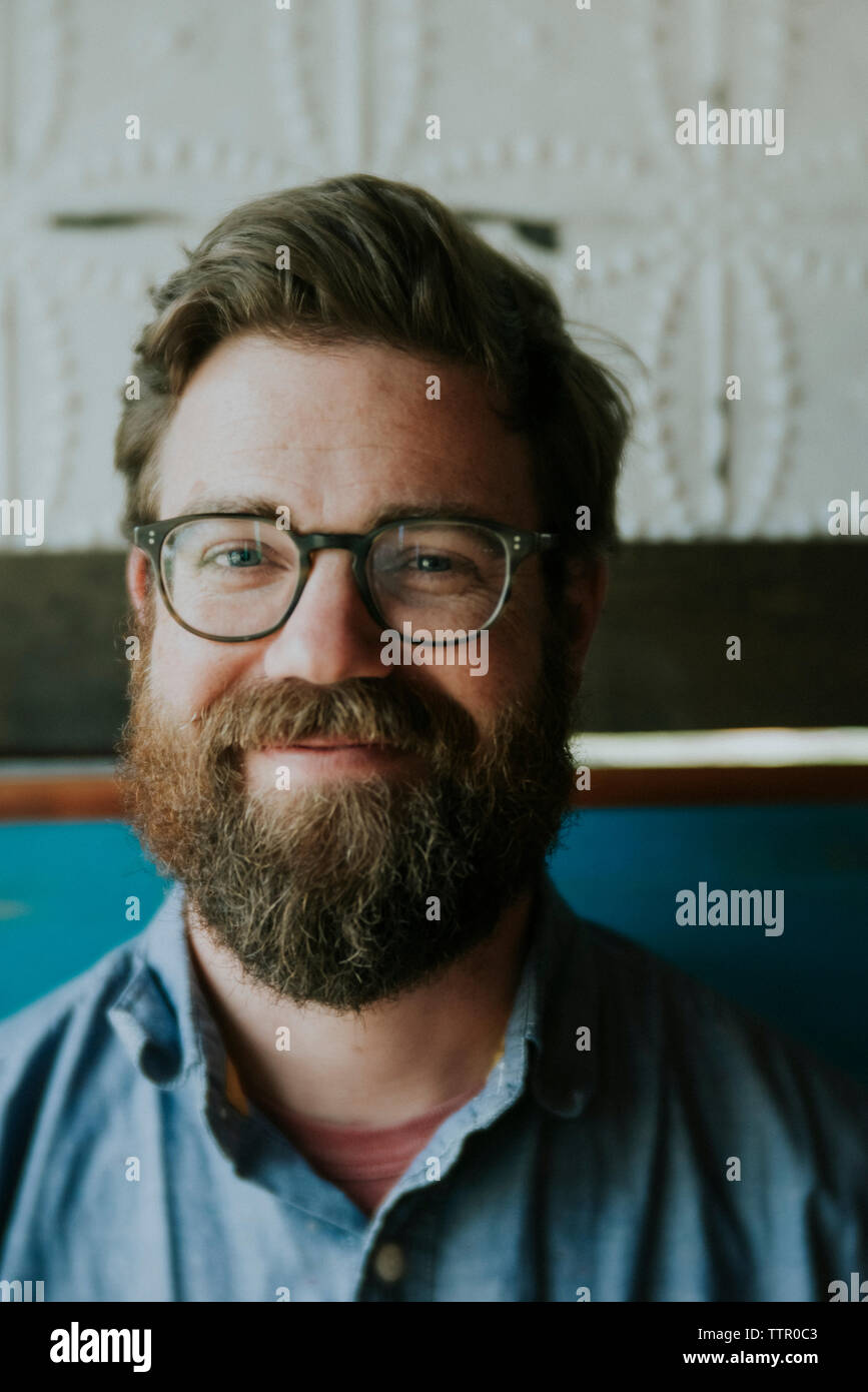 Nahaufnahme Porträt der Mann mit Bart Brillen tragen, während zu Hause sitzen Stockfoto
