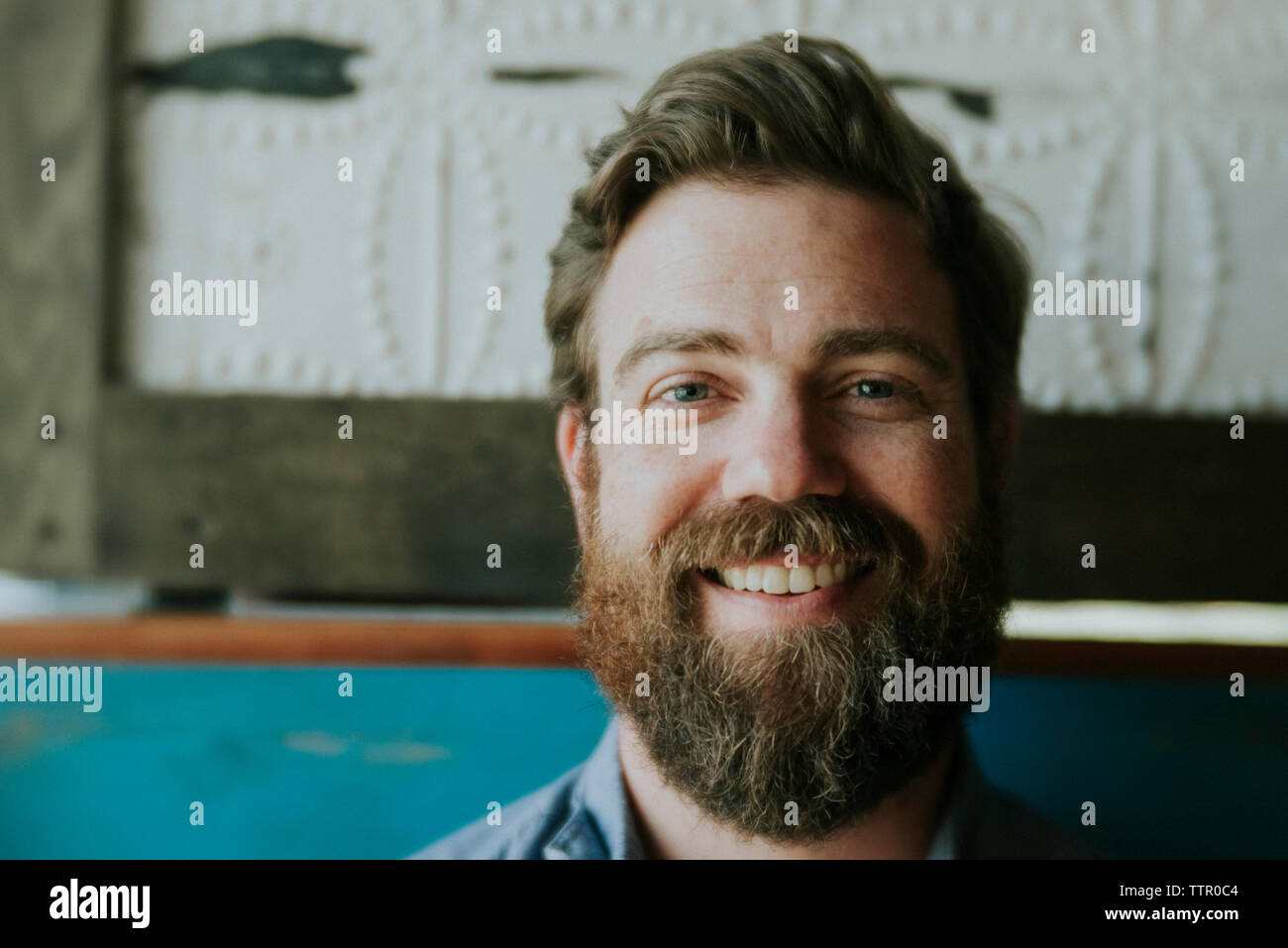 Close-up Portrait von glücklicher Mann mit Bart zu Hause sitzen Stockfoto