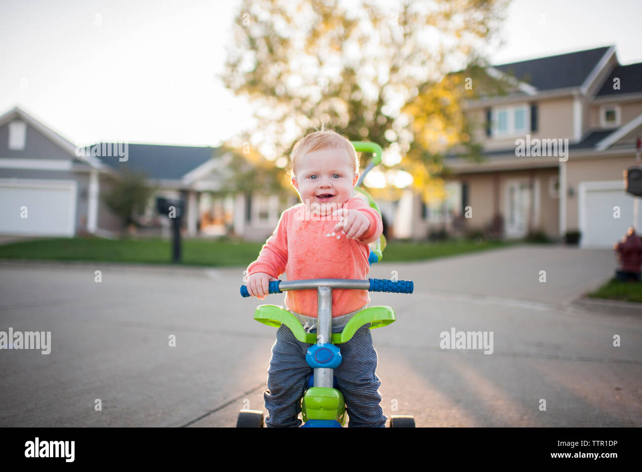 Portrait von fröhlichen Baby auf Dreirad Stockfoto