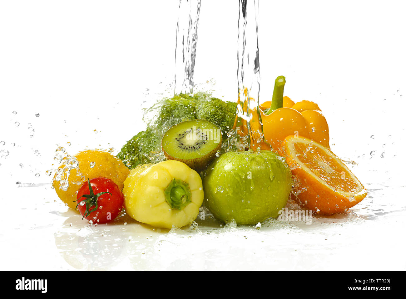 Gemüse und Früchte mit Spritzwasser auf weißem Hintergrund Stockfoto
