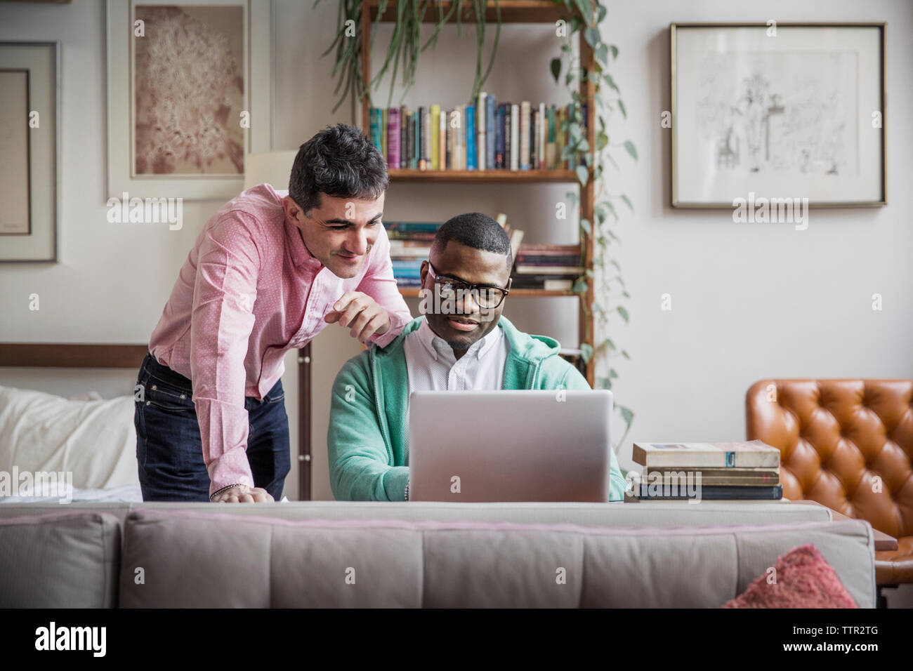 Homosexuelle Männer mit Laptop zu Hause Stockfoto