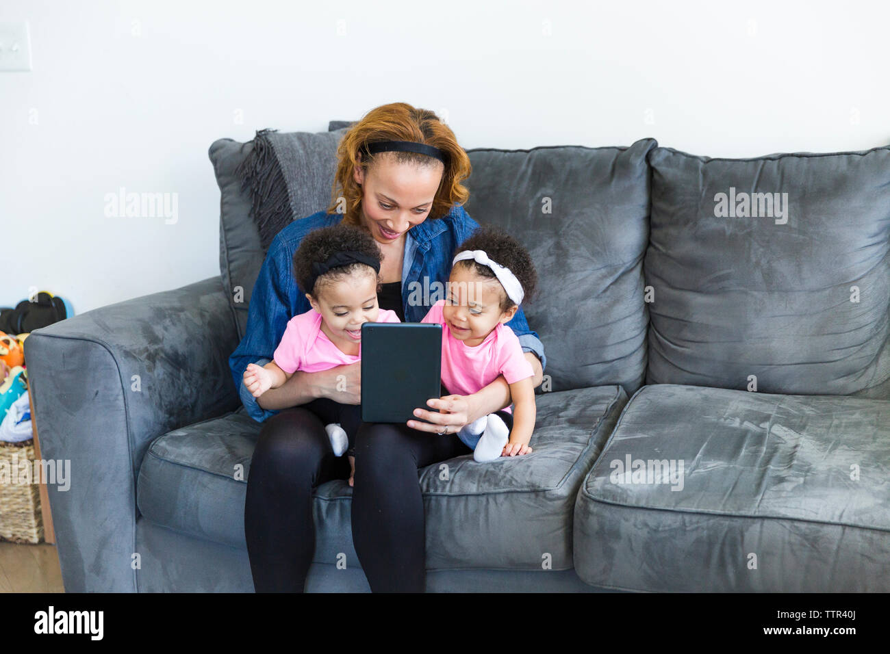 Mutter und Töchter auf der Suche nach Tablet Computer beim Sitzen auf dem Sofa Stockfoto