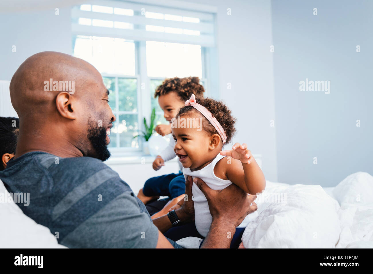 Gerne Vater spielen mit den Kindern, während sie sich auf dem Bett zu Hause. Stockfoto