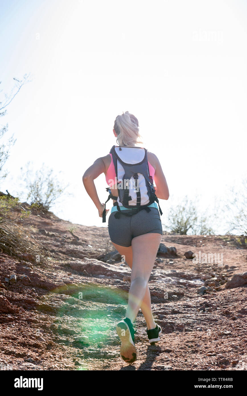 Ansicht der Rückseite des weiblichen Wanderer, die auf Berg gegen den klaren Himmel während der sonnigen Tag Stockfoto