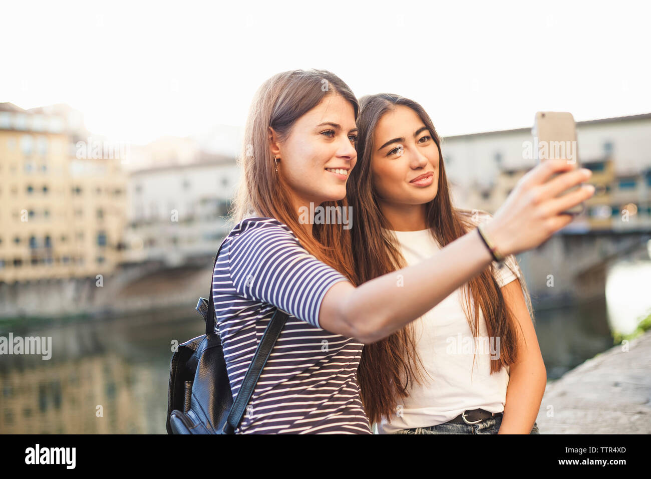 Lächelnd Freunde unter selfie mit smart phone gegen Kanal in der Stadt Stockfoto