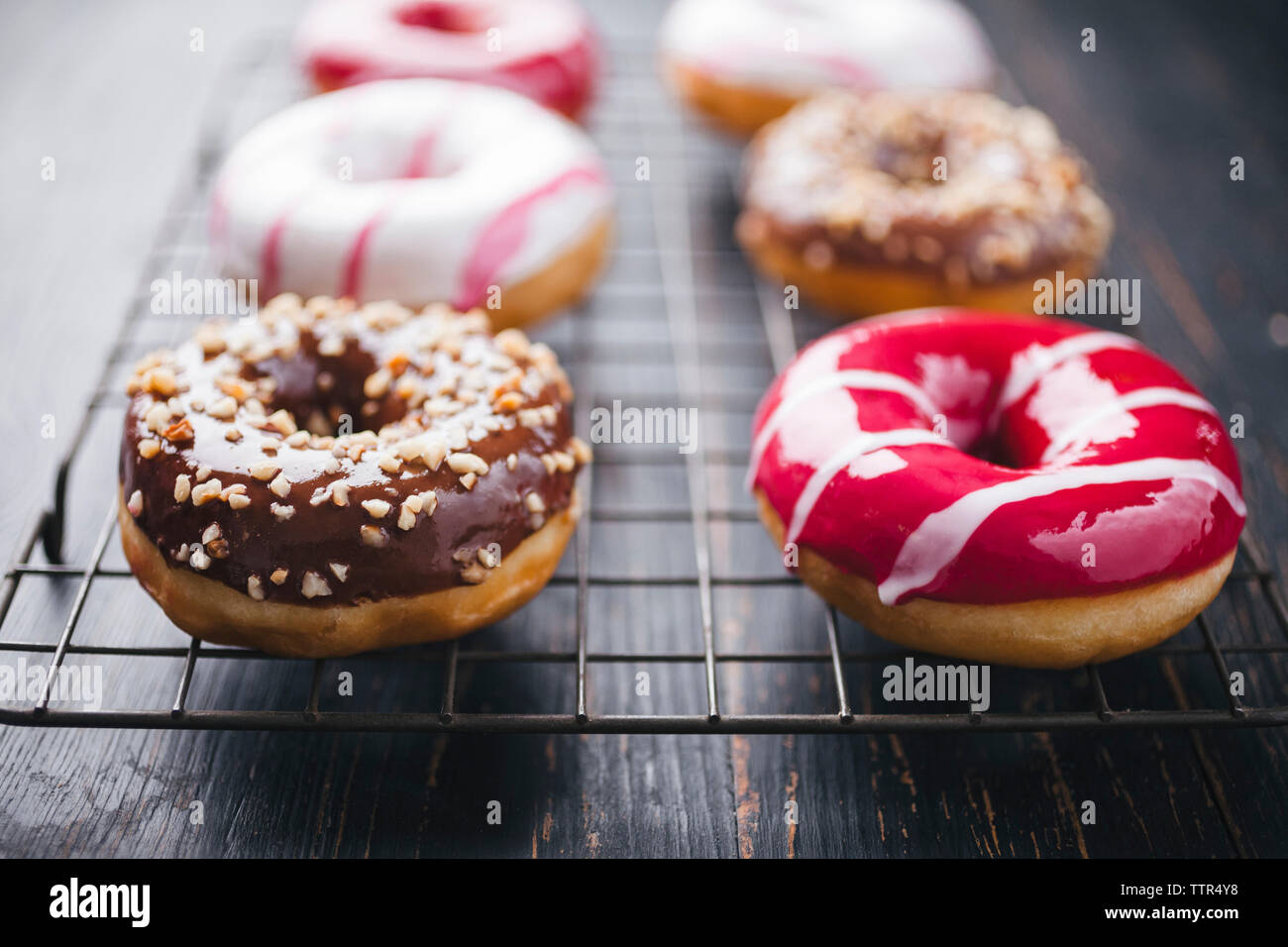 Hohen Winkel Nahaufnahmen der bunte Donuts auf Kühlung Rack Stockfoto