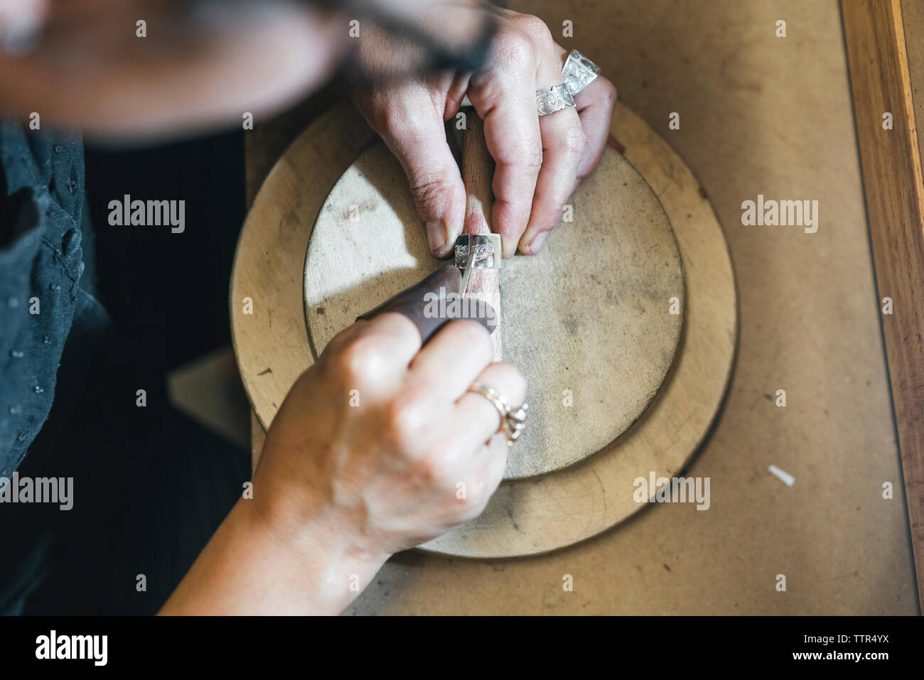 Hohe Betrachtungswinkel der weiblichen handwerkliche Herstellung von Schmuck am Tisch in der Werkstatt Stockfoto