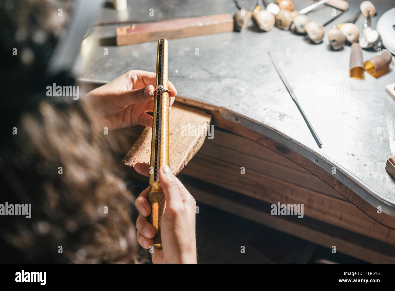 Zugeschnittenes Bild der weiblichen Schüler messen Ring über Tabelle in der Werkstatt Stockfoto