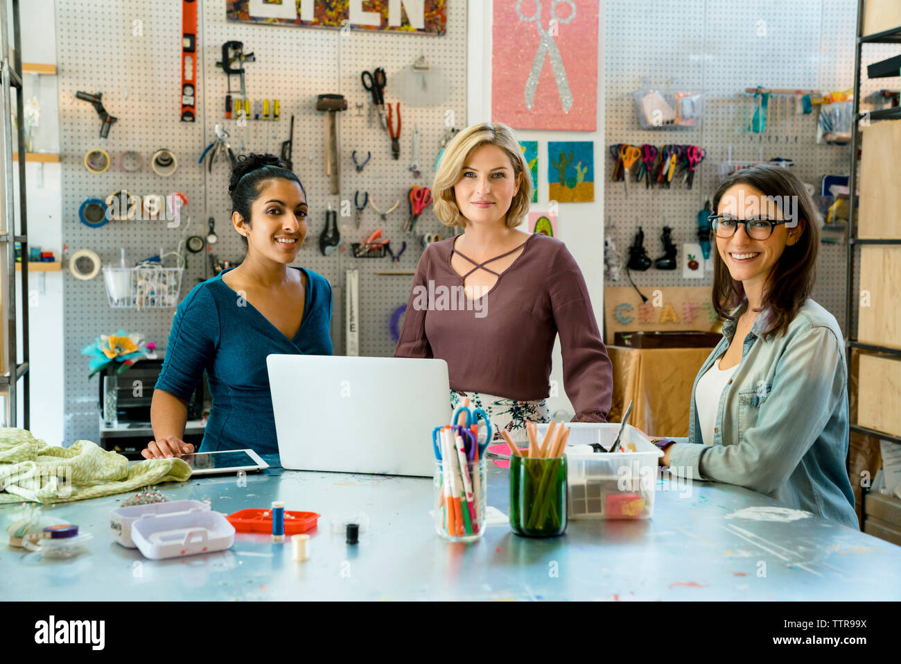 Portrait von zuversichtlich Geschäftsfrauen durch Werkbank stehend Stockfoto