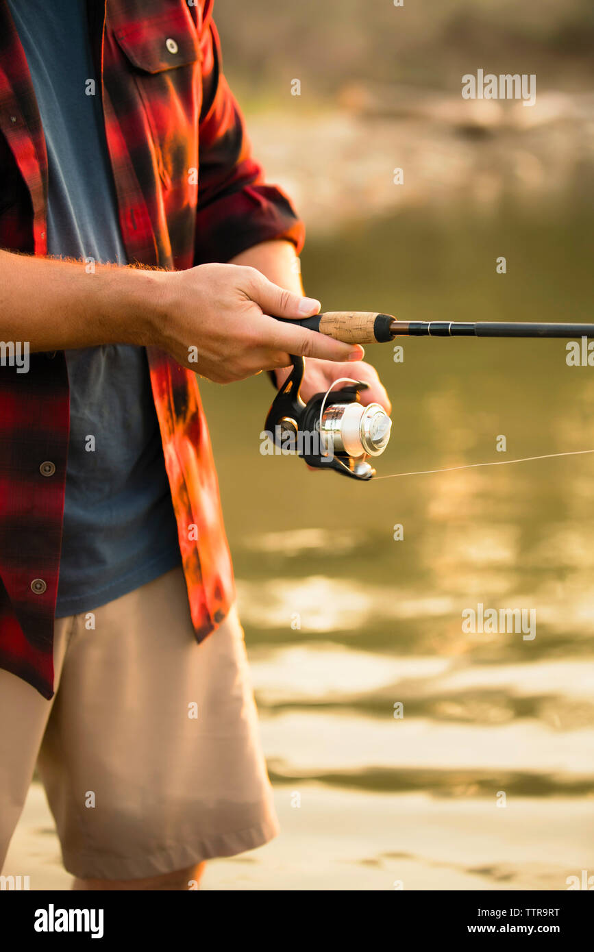 Mittelteil der Mitte der erwachsene Mann angeln beim Stehen in der See Stockfoto