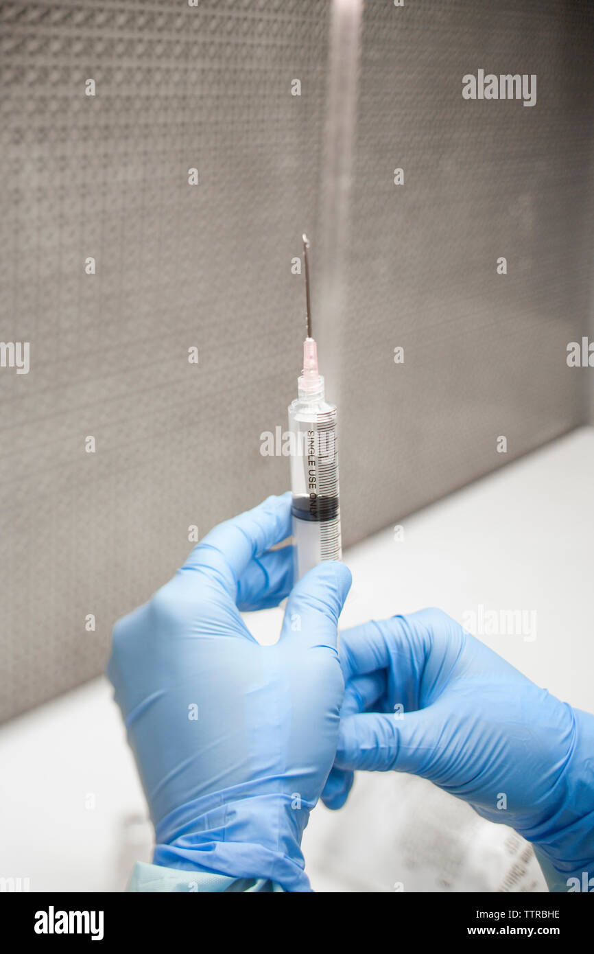 7/8 Hände der Zahnarzt Prüfung Medizin in Spritze Stockfoto