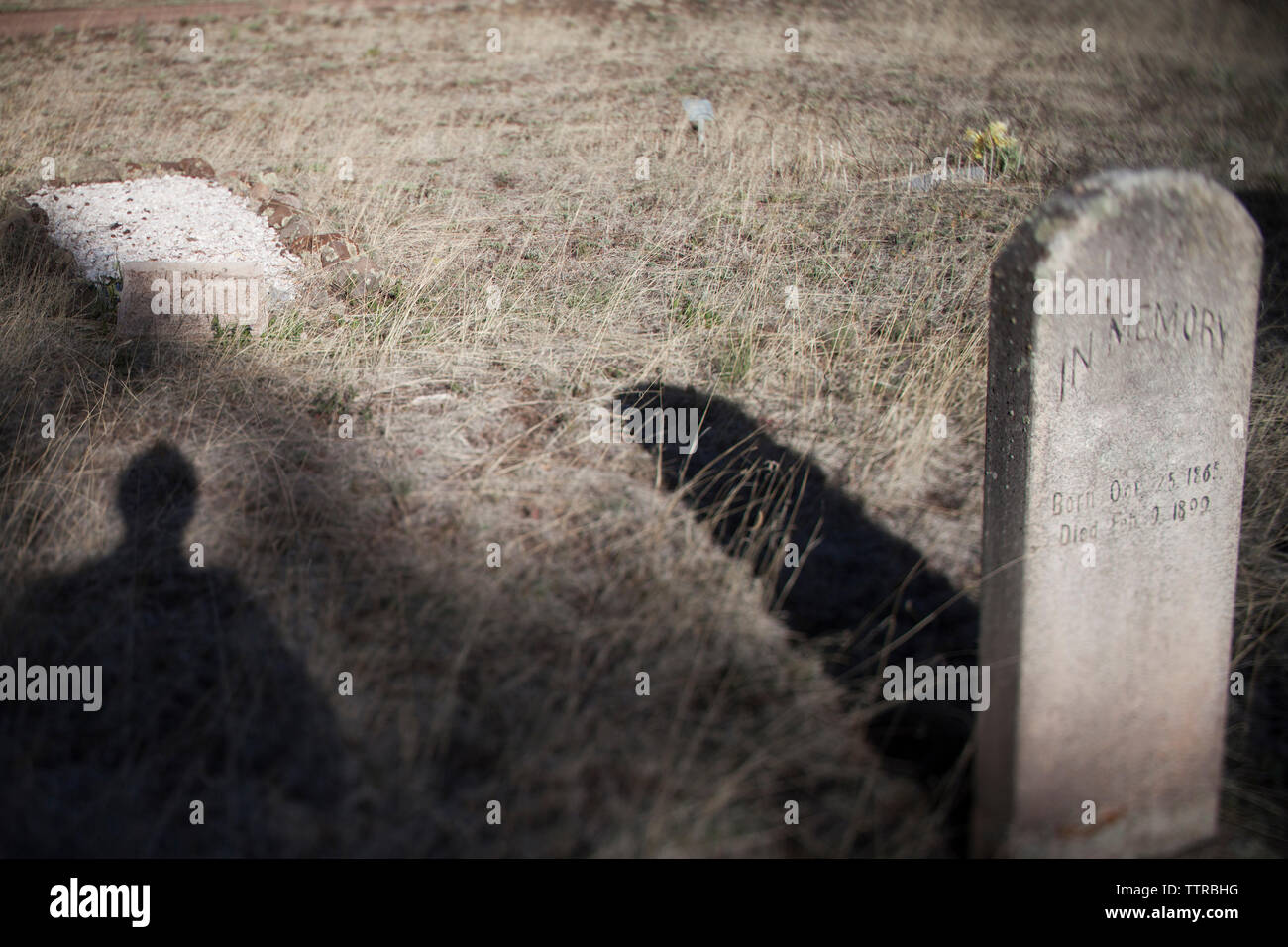 Schatten der Person auf dem Feld am Friedhof Stockfoto