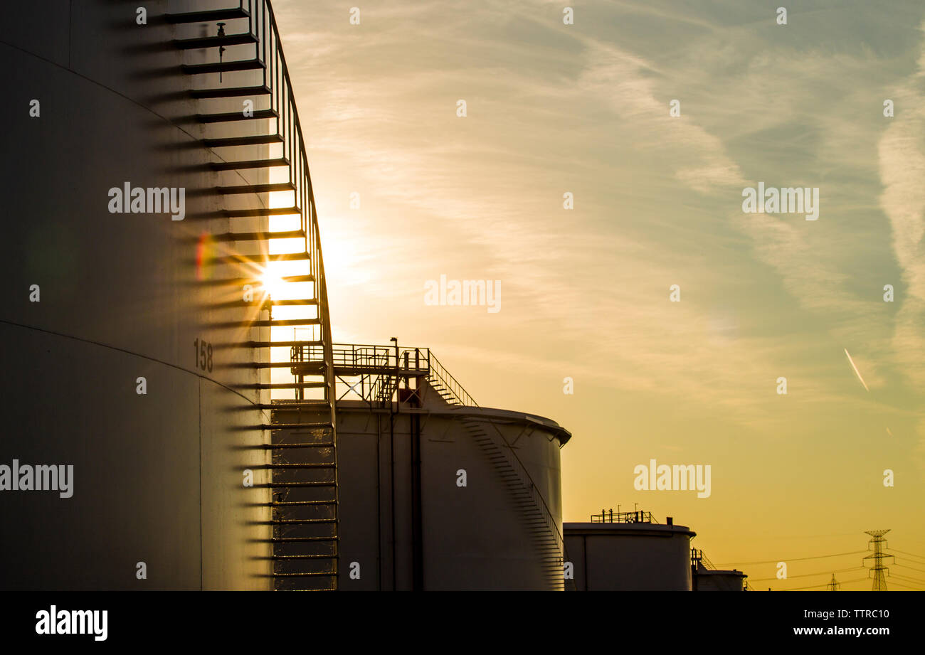 Low Angle View von Lagertanks in der Ölraffinerie gegen Himmel bei Sonnenuntergang Stockfoto