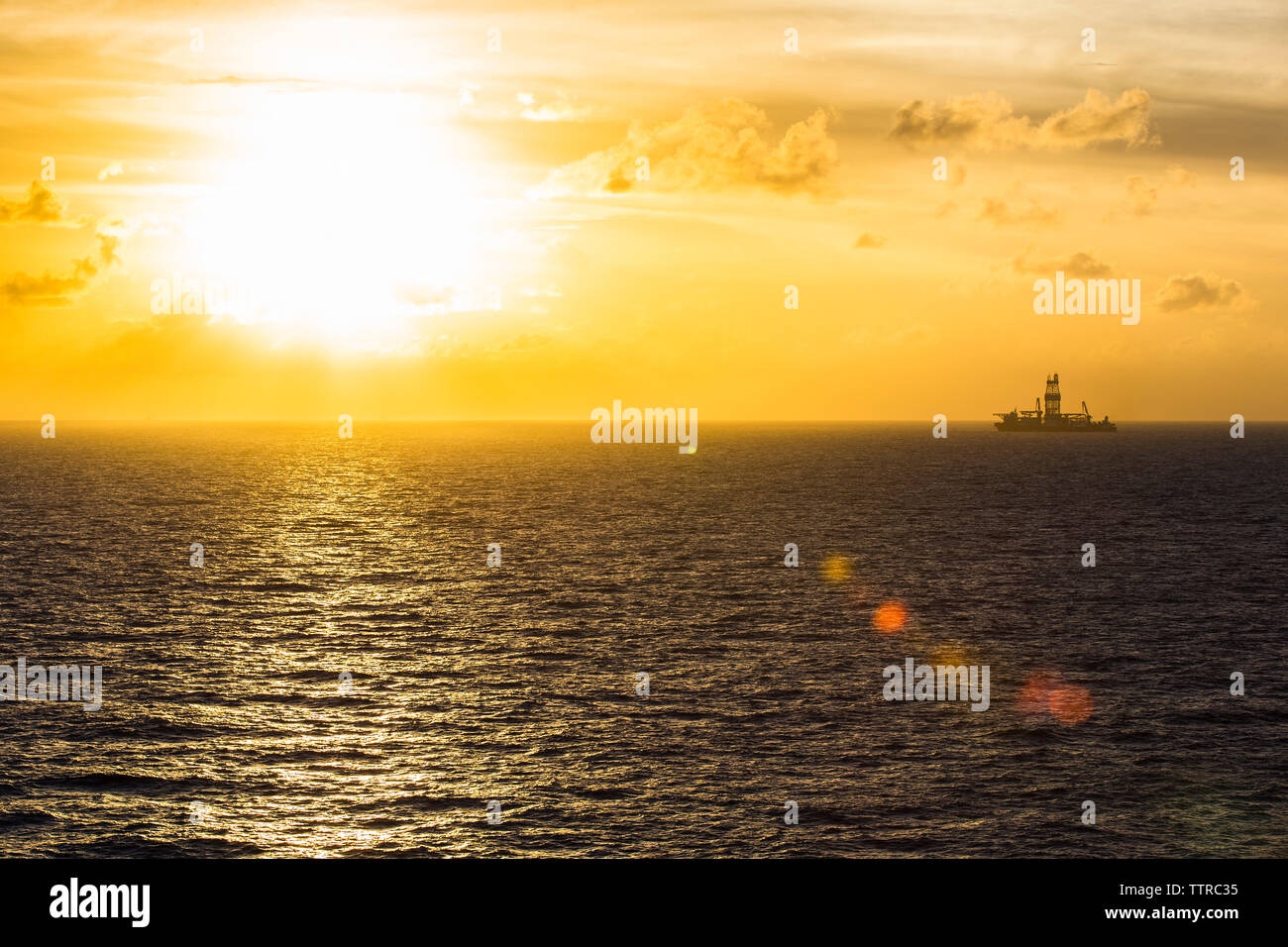 Fernsicht auf Bohrinsel im Meer gegen Himmel bei Sonnenuntergang Stockfoto