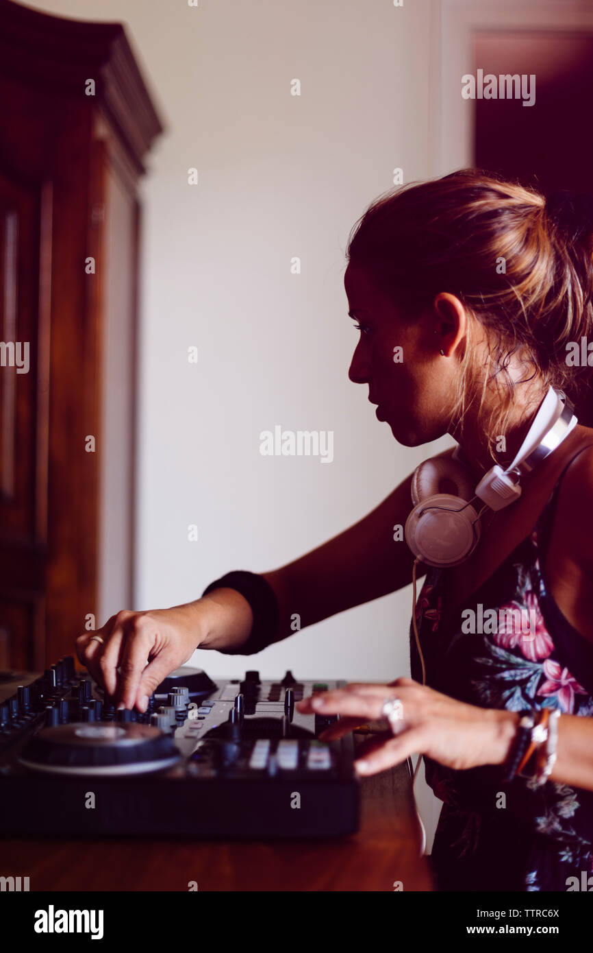 Seitenansicht der weiblichen DJ Mixing Sound während der Sitzung in Recording Studio Stockfoto