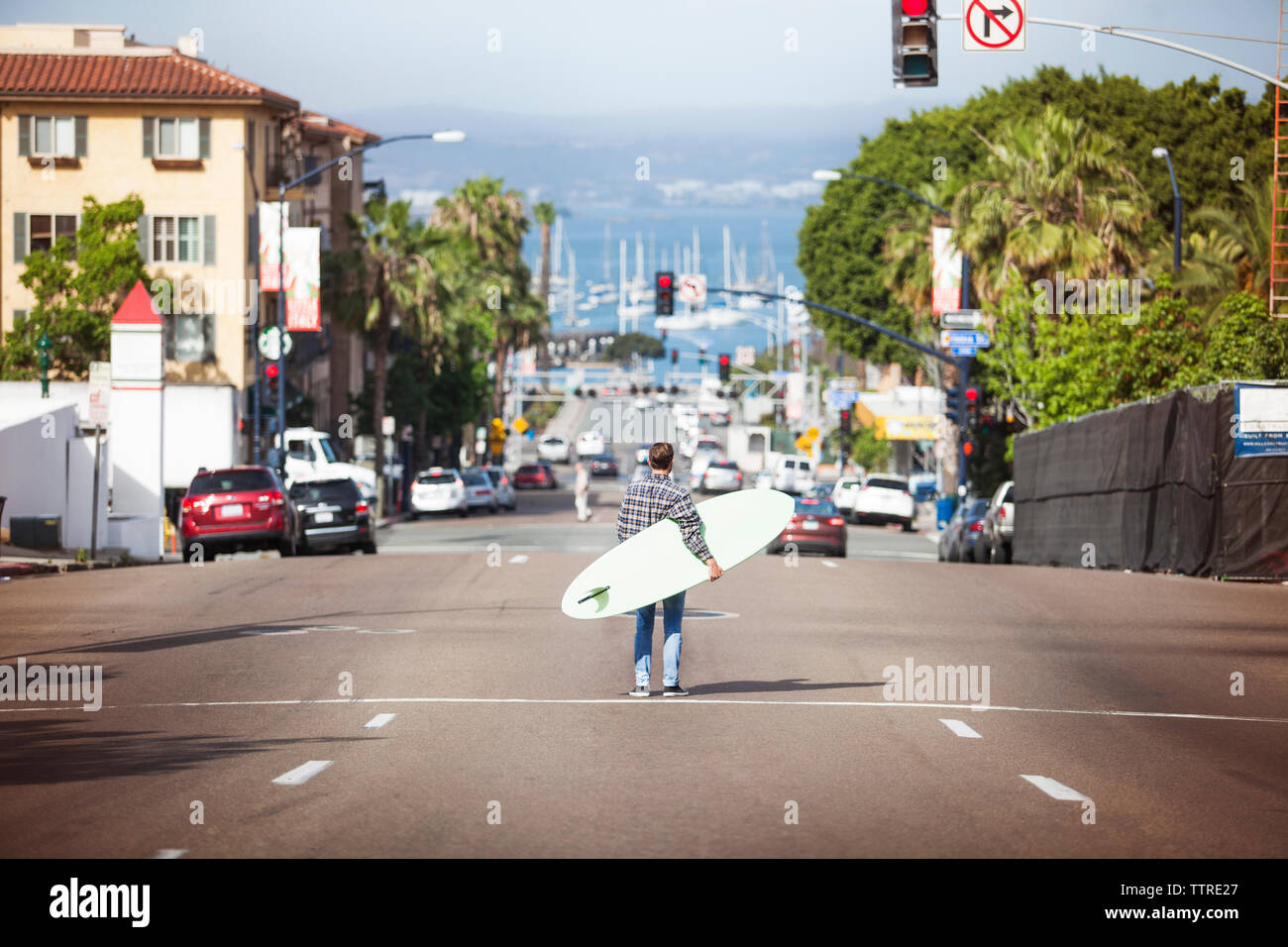 Ansicht der Rückseite des Mann mit Surfbrett und stehen auf der strasse Stockfoto