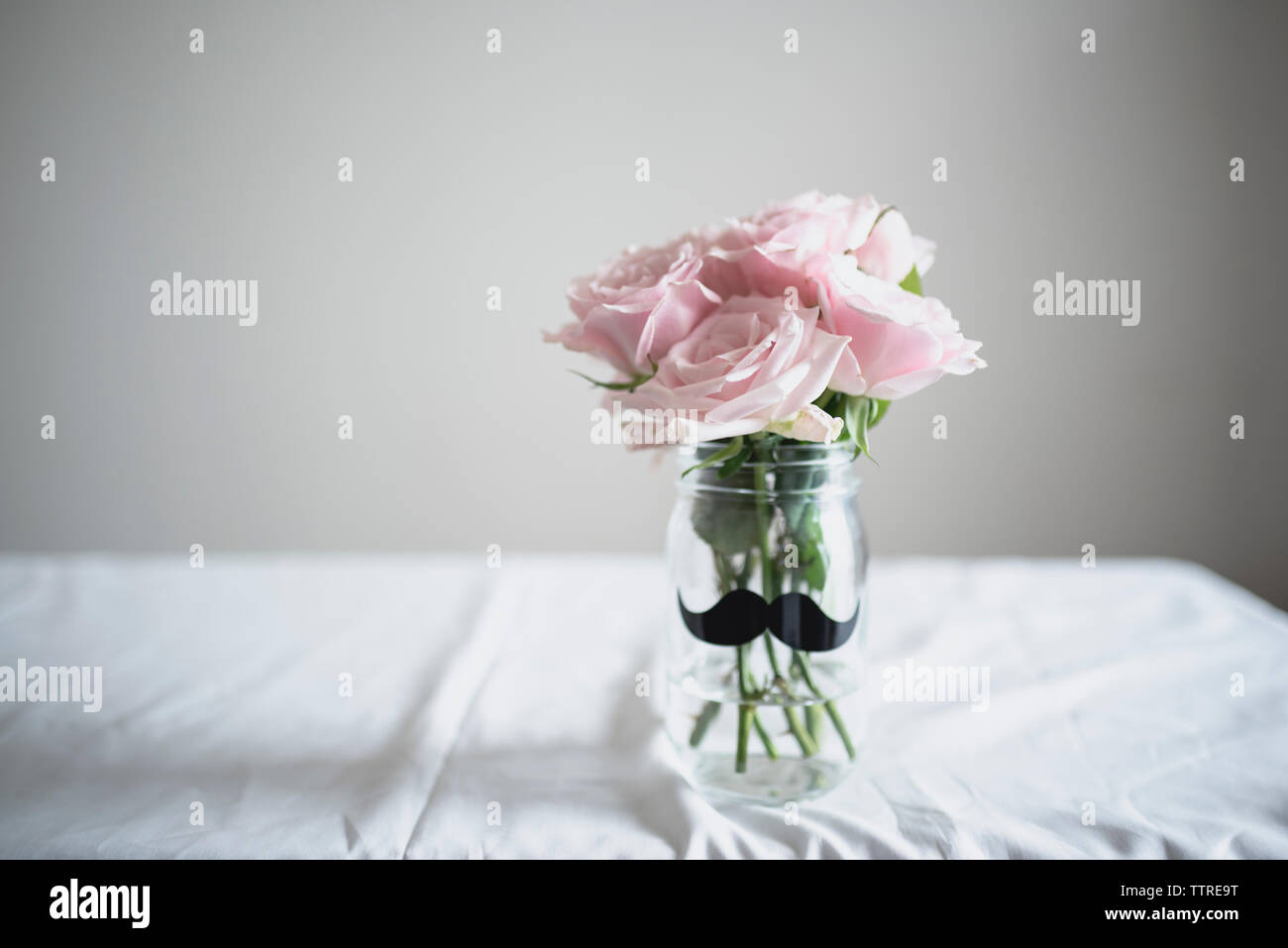Rosen im Glas auf dem Tisch zu Hause Stockfoto
