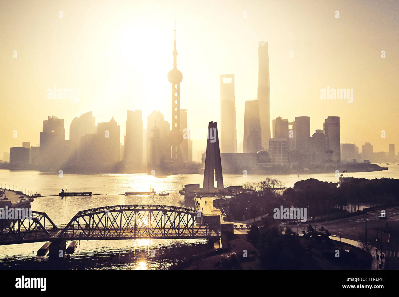 Silhouette Brücke über den Fluss Huangpu gegen Hochhäuser bei Sonnenuntergang Stockfoto