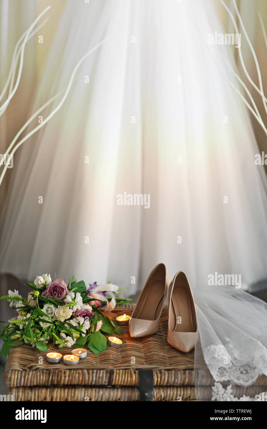 Schuhe auf wicker Brust und Hochzeit Kleid hängen an der Wand im Zimmer Stockfoto