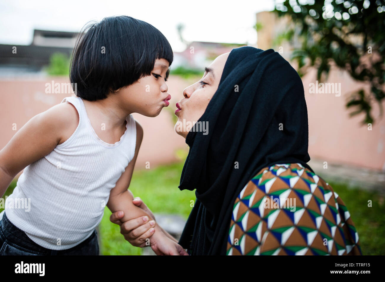 Verspielte Mutter und Sohn verziehenden Lippen im Hinterhof Stockfoto