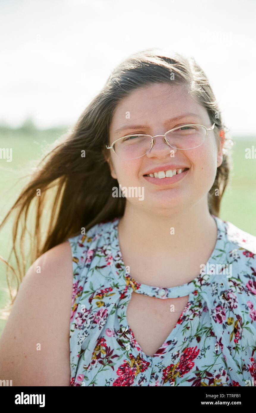 Portrait von übergewichtigen Teenager tragen Brillen lächelnd auf Feld während der sonnigen Tag Stockfoto