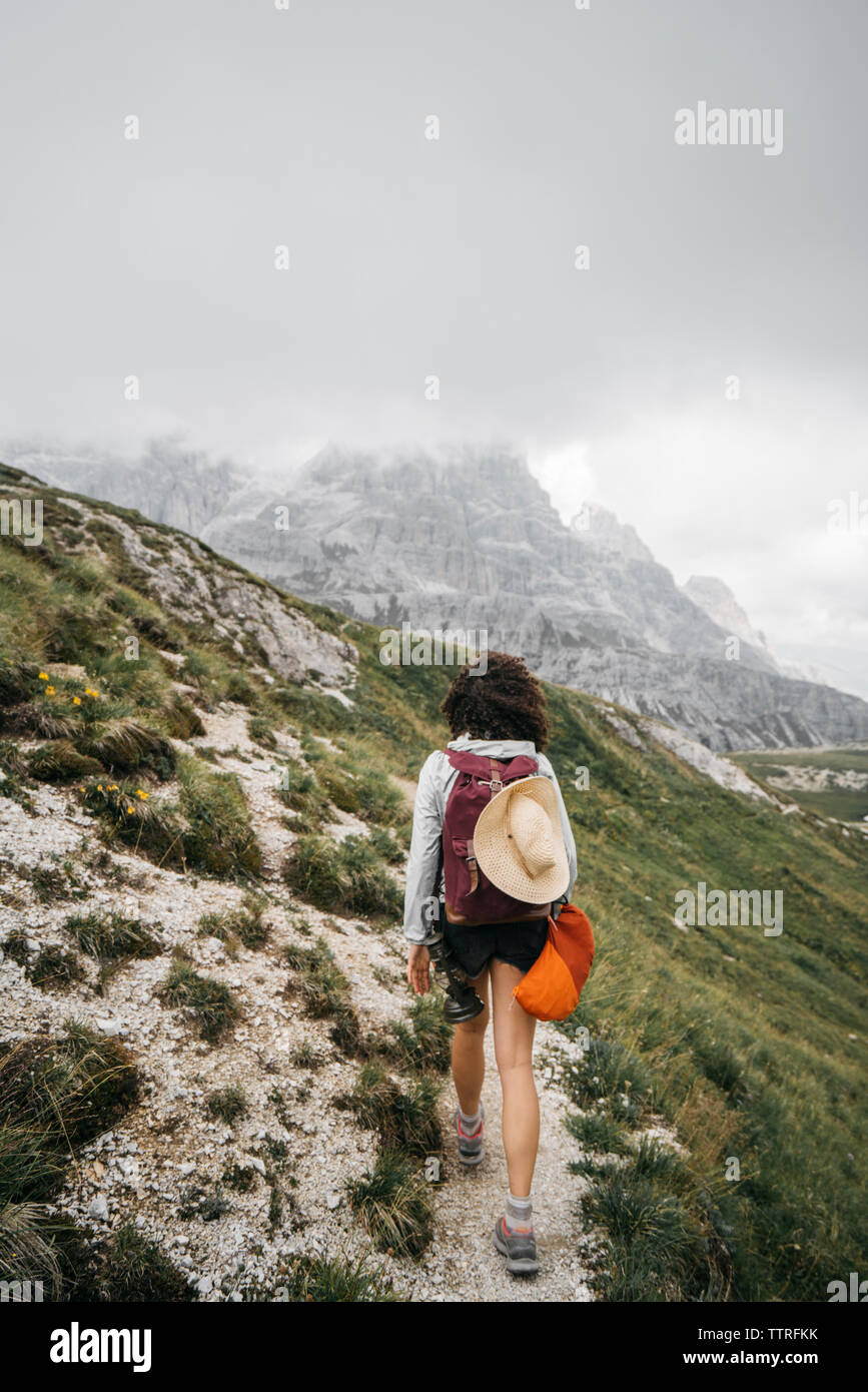 Ansicht der Rückseite des weiblichen Wanderer zu Fuß auf den Berg gegen bewölkter Himmel Stockfoto