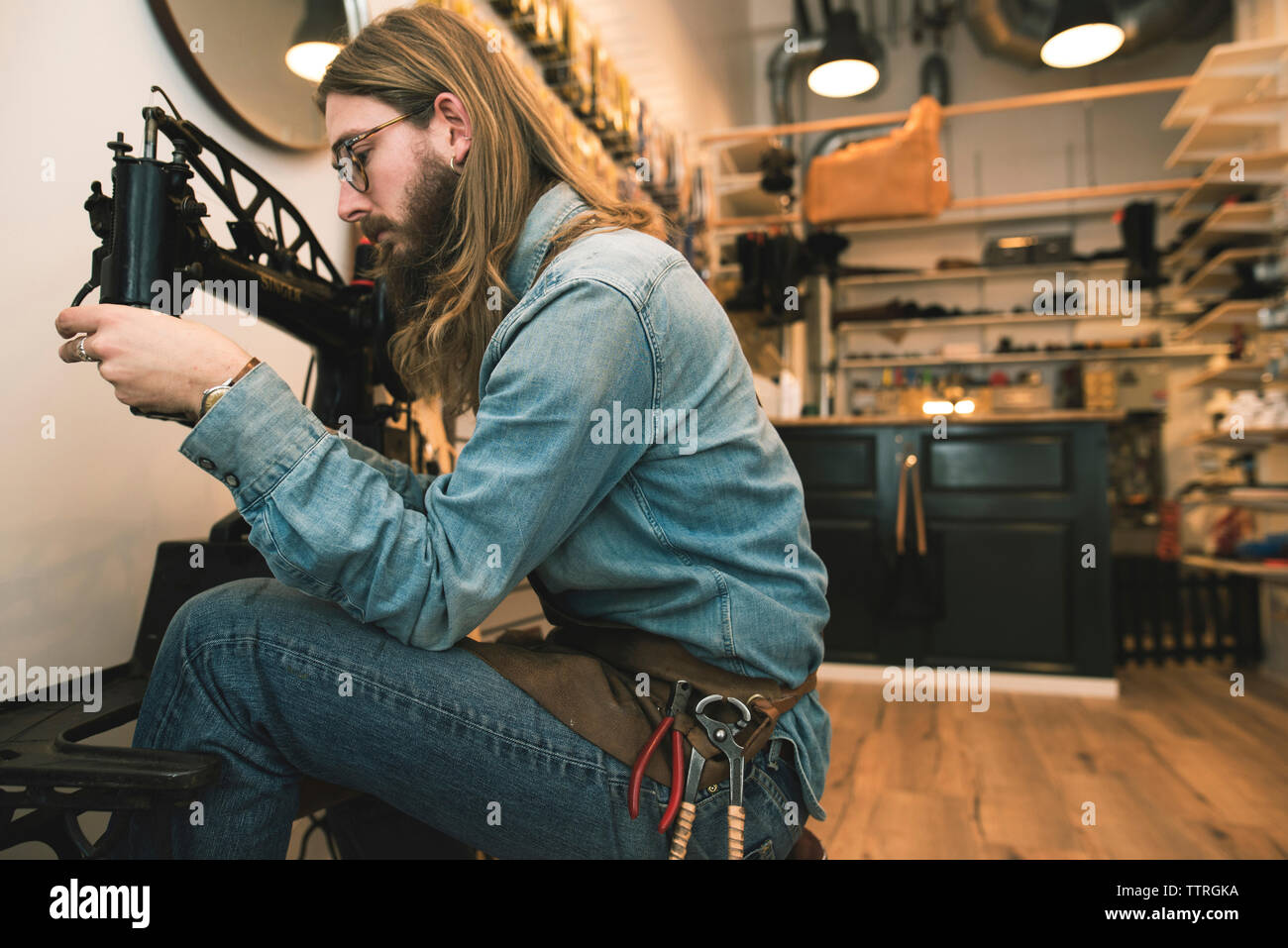 Seitenansicht der Schuhmacher einstellen Nähmaschine workshop Stockfoto