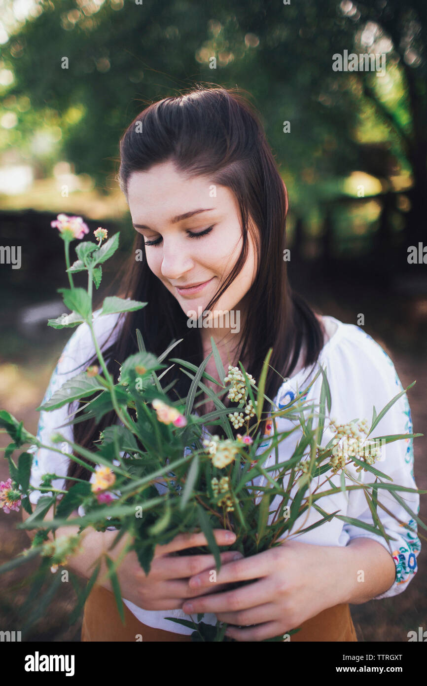 Lächelnd teenager Pflanzen, während im Hof stehend Stockfoto