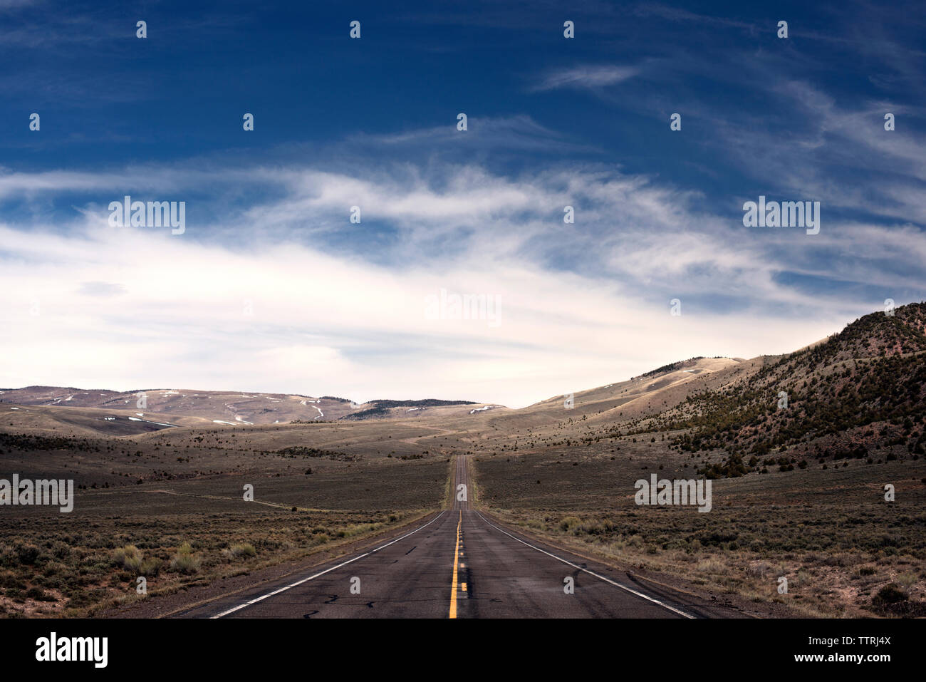 Leere Straße inmitten von Feld gegen Sky Stockfoto