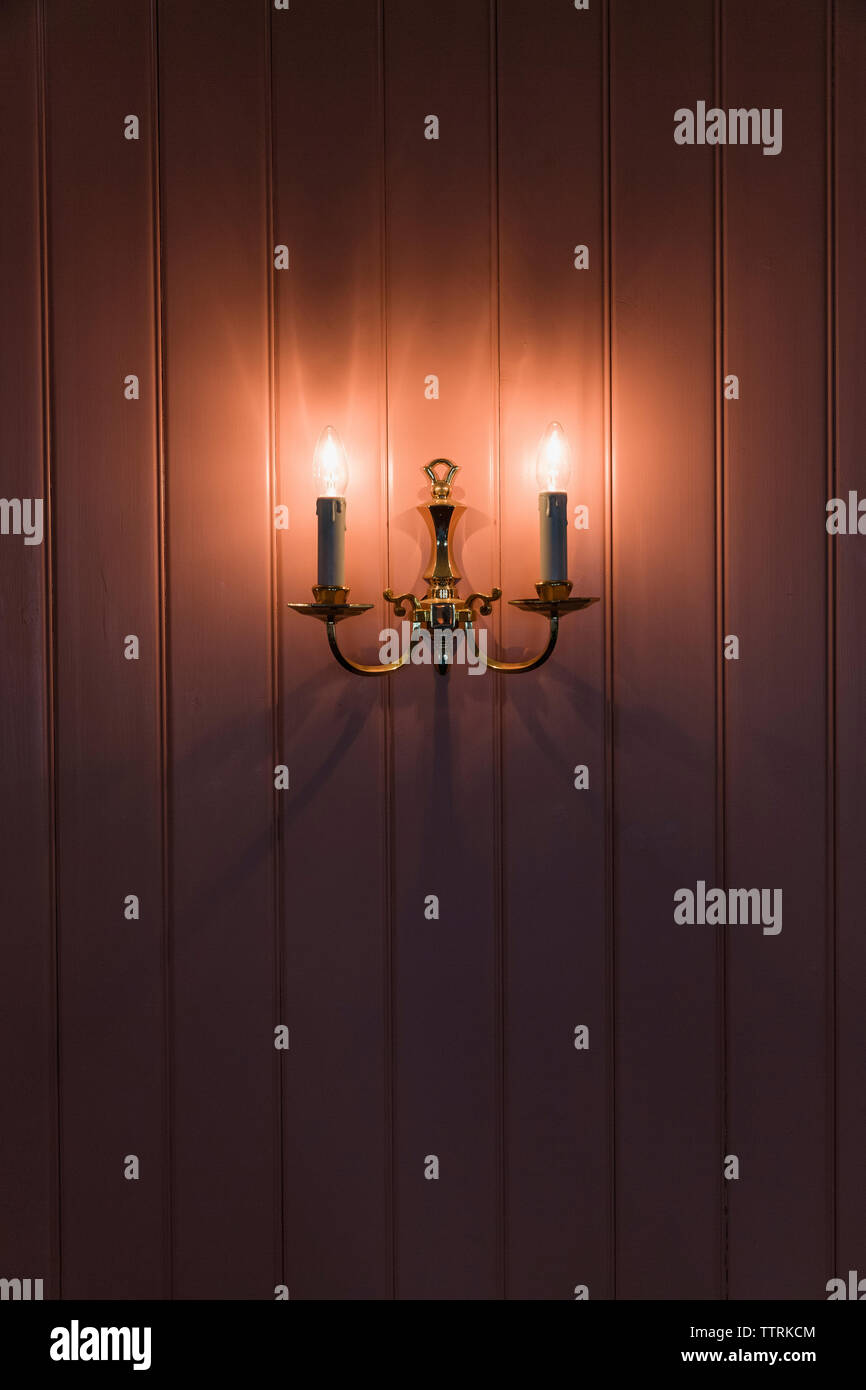 Beleuchtete Lampen an der Wand im Zimmer montiert Stockfoto