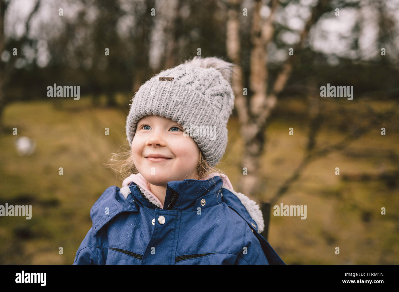 Positive Kind im Winter tragen Sie im Park auf unscharfen Hintergrund Stockfoto