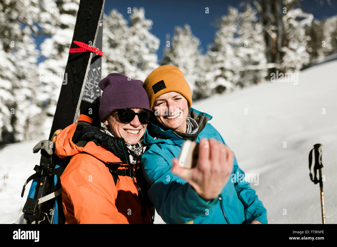 Gerne Freunde sprechen selfie beim Stehen auf Schnee bedeckten Hügel Stockfoto