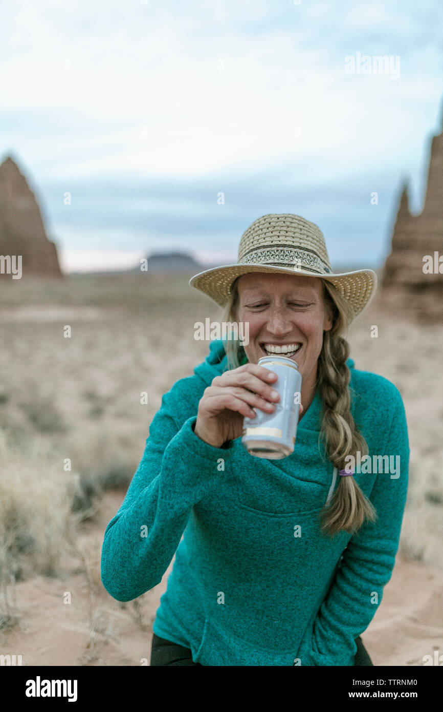 Freundliche weibliche Wanderer tragen hat beim Drink an der Wüste Stockfoto