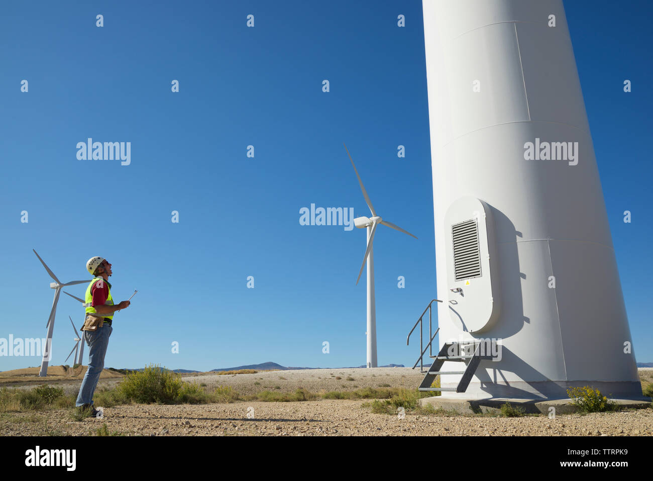 Techniker stehen auf gegen den klaren blauen Himmel Stockfoto