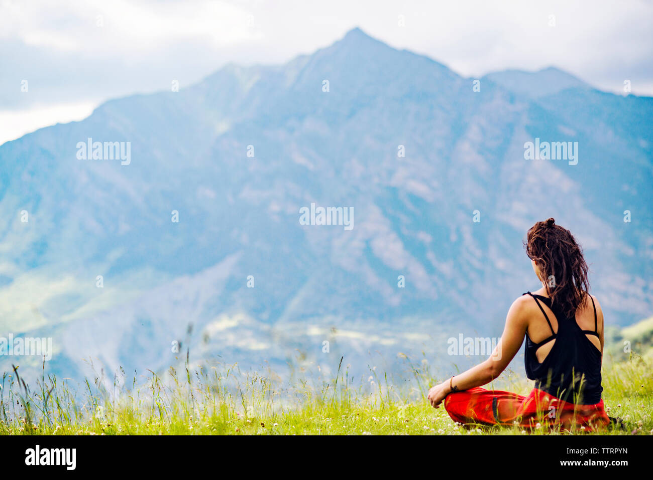 Ansicht der Rückseite frau yoga gegen Berge Stockfoto