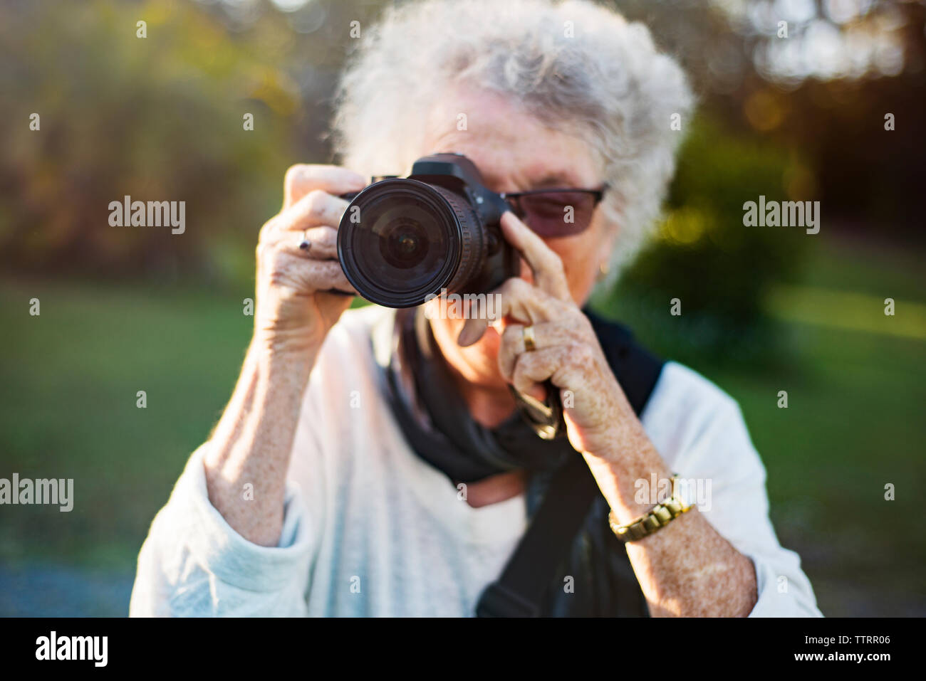 Nahaufnahme der älteren Frau Fotografieren durch die Kamera in Park Stockfoto