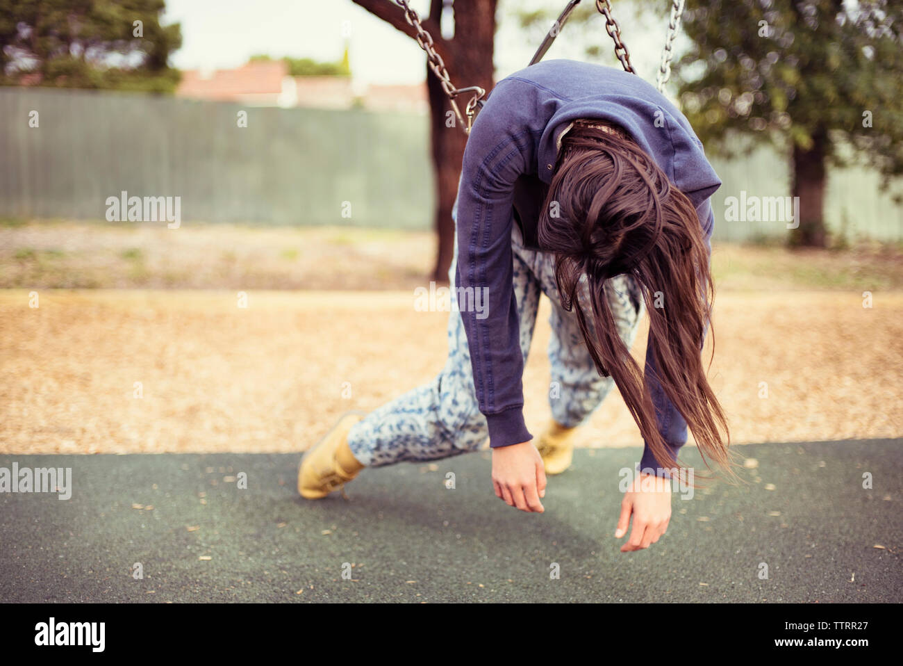 Traurige Frau auf Schaukel am Spielplatz liegen Stockfoto